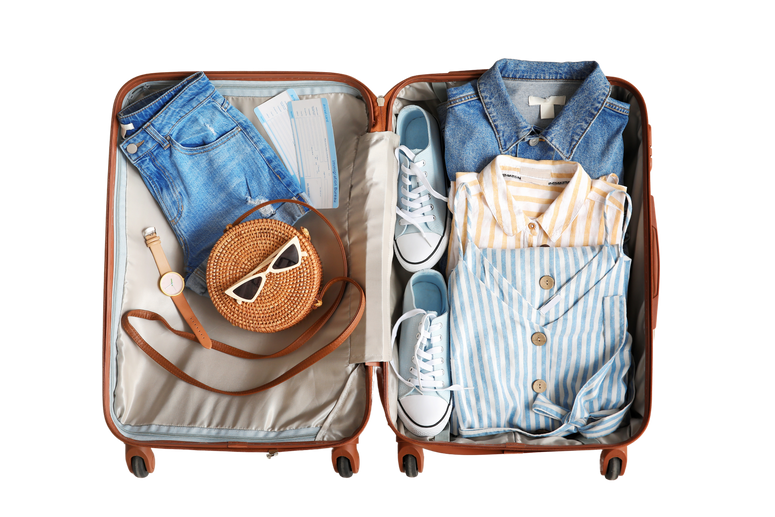 Open Packed Suitcase on Wooden Background